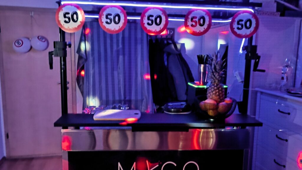 Beleuchtete mobile Cocktailbar von MyCo bei Event mit Cocktailmaschine und Bar