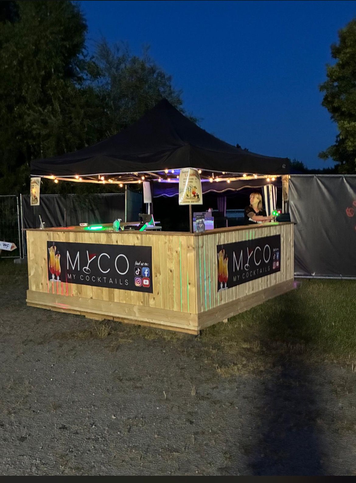 MyCo Pop-up-Holzbar am Abend mit Lichterkette